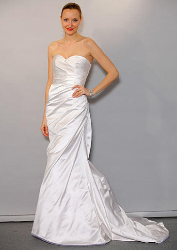 A clean white sheath ruched at the bust and waist has a petite train so the bride can make the most of her walk down the aisle.