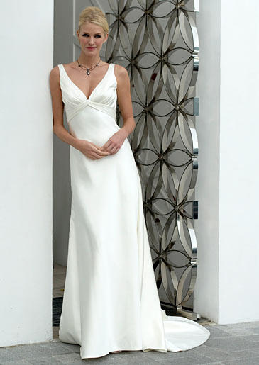 An Augusta Jones empire waist gown has a plunging neckline and fluid skirt with a short train.
