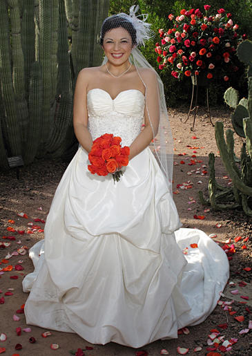 A satin ball gown has pickups in the front and a romantic train trailing in the back.
