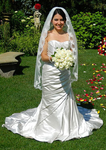 This satin A-line gown wraps around the bride's body before pooling into a simple train.
