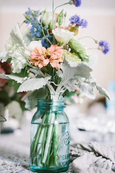 Flowers become country vintage chic when arranged effortlessly in a blue Mason jar.