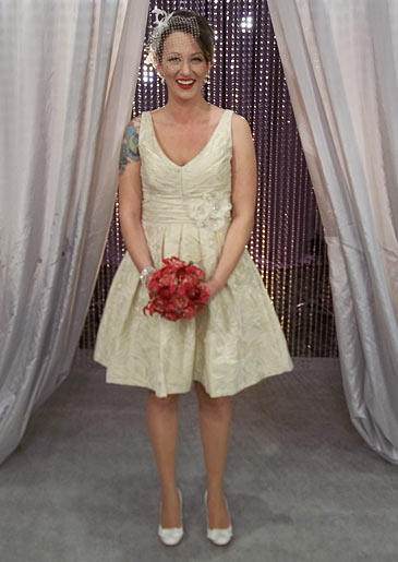 A champagne brocade short dress with plunging V-neck and flower detail at the waist is vintage chic.