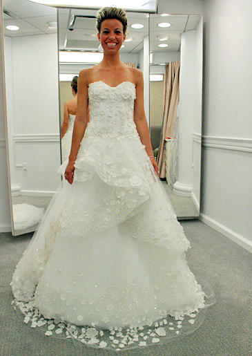 A tulle skirt embroidered with flowers adds femininity and texture to this white wedding dress.