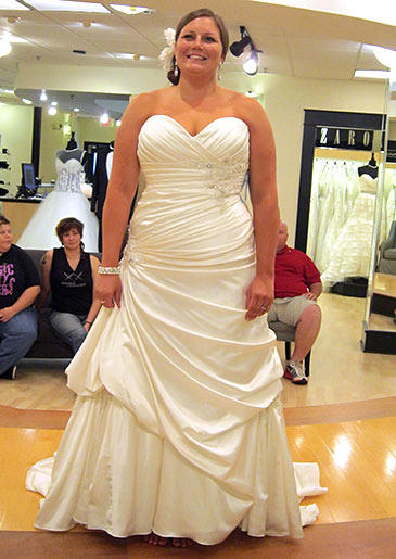 This ivory A-line wraps around the bride's body and has pickups at one thigh to elongate and slim the figure.