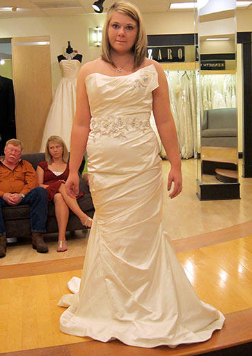 This champagne satin gown is embellished with flowers at the waist and shoulder.