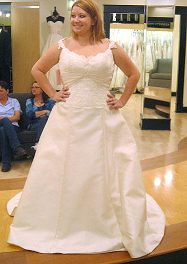 This regal ivory ball gown has a floral embroidered bodice and embroidered straps that sit at the edge of the shoulder.
