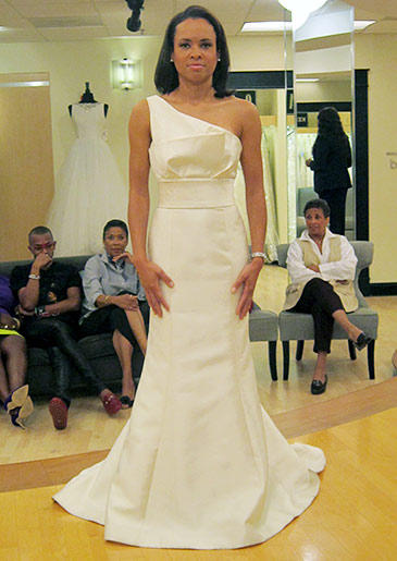 This sleek, highly structured fit and flare has a strap across one shoulder.