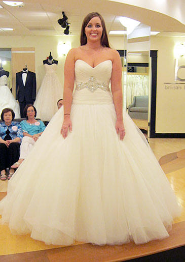 The dropped waist on this ball gown makes the style slightly more contemporary; crystal beadwork at the waist eliminates the need for too many bridal accessories.
