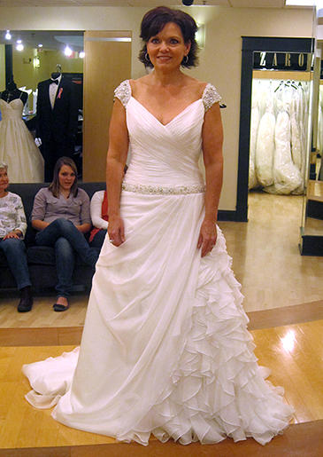 Beaded cap sleeves complement the beaded dropped waist of this ruffled organza A-line dress.