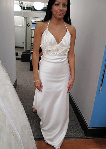 An empire waist is set off by a floral detail in the center of the bust, and a narrow halter strap lends extra support for the bust.