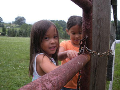 Alexis and Hannah lock the gate to the chicken coop, so the new family pets aren't running loose! Kate already has eight kids to run after. She doesn't need to chase chickens, too.