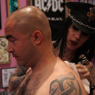 After Aaron makes his decision, Kat begins by carefully shaving, cleaning and disinfecting the location of the intended tattoo. Then, she will trace the outline using an imprint of the design.