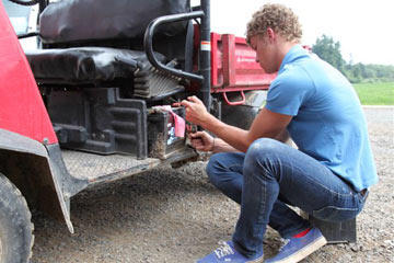 Jeremy Roloff, one of the twins, fixes a tractor. As one of the oldest and tallest members of the Roloff family, it is his job to drive the tractors filled with pumpkin seekers each fall.