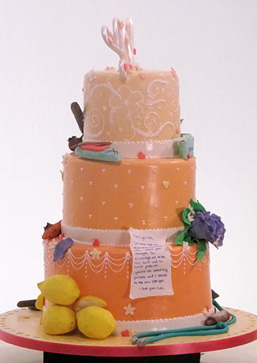 Team Ashley and Gretel-Ann created this bright peach cake with symbols representing their moms. Even though the piped icing melted and smeared, the details were professional enough to have it declared the winner!