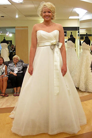 Megan wears Amsale Style Sabrina.
Fabric: tulle
Description: ball gown with side ruched bodice, satin sash
Color: ivory
Price: $$$$