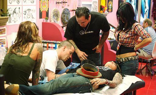 The LA Ink crew watching Steve-O tattooing Kat.