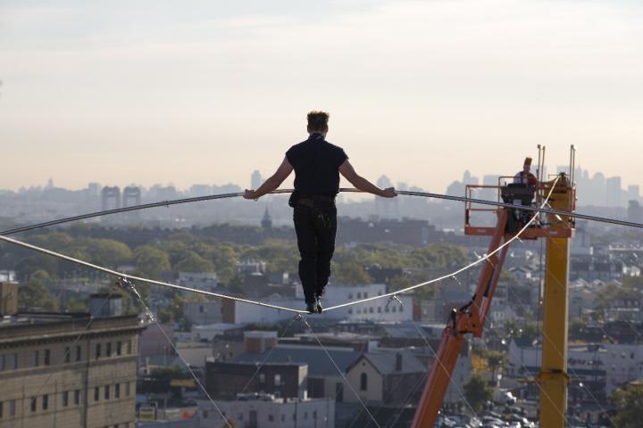 Nik Wallenda walks the high wire towards a crane.