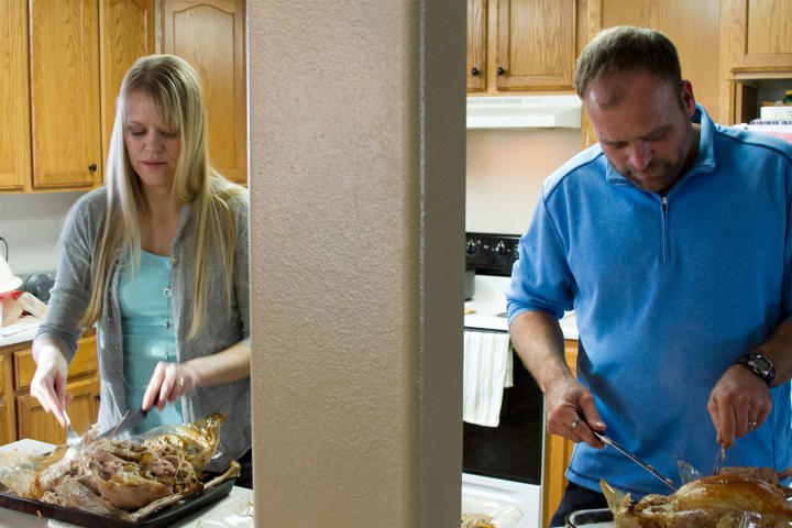 Robyn and Brady carve turkeys for the family's Thanksgiving feast. The family usually cooks two large turkeys, one small turkey and one ham.