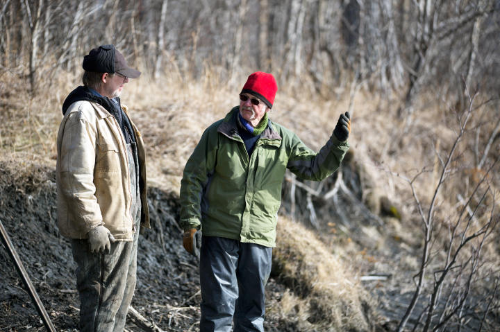 Atz Kilcher and Otto Kilcher talk over possible options to get supplies across the river because of the poor ice layer that is making it difficult for them.