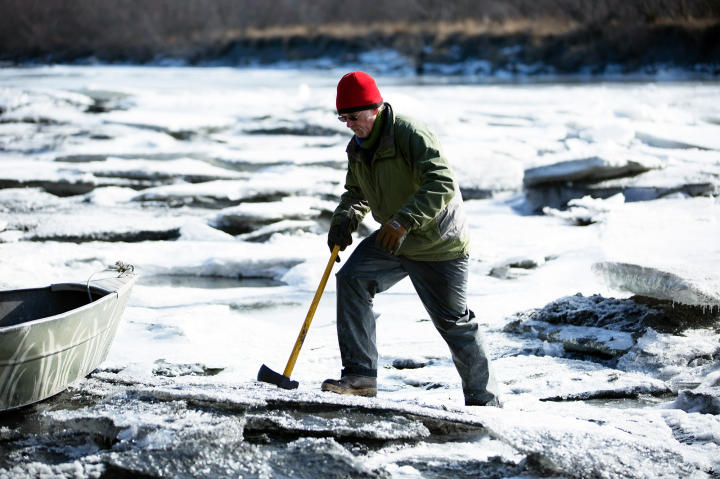 Atz Kilcher on the river's ice layer to check its thickness.