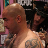 After Aaron makes his decision, Kat begins by carefully shaving, cleaning and disinfecting the location of the intended tattoo. Then, she will trace the outline using an imprint of the design.