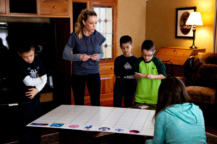 The kids take turns signing up on the game board.
