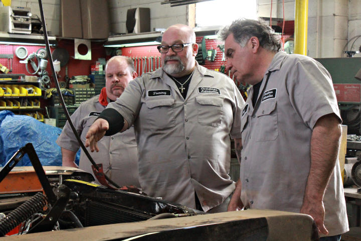 Chuck Kountz, Tommy Christmas, and Andy Pivarnik making a plan for a hemi engine install.
