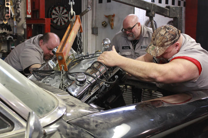 Chuck Kountz, Tommy Christmas, and Steve McGranahan installing a new hemi engine.