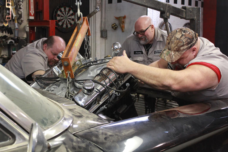 Chuck Kountz, Tommy Christmas, and Steve McGranahan installing a new hemi engine.