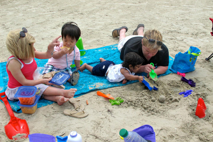 Lunchtime and playtime are combined at the beach.