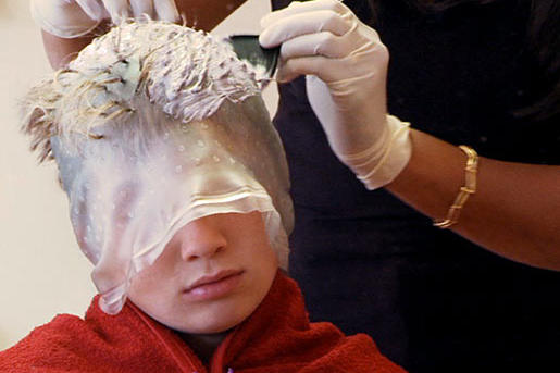 A gypsy boy gets highlights at a hair salon.
