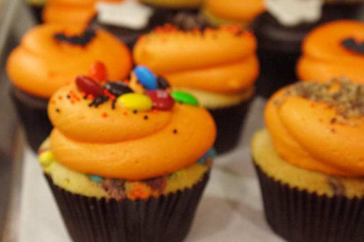 These trick-or-treat candy bar cupcakes feature 12 different types of candy and totally festive frosting.