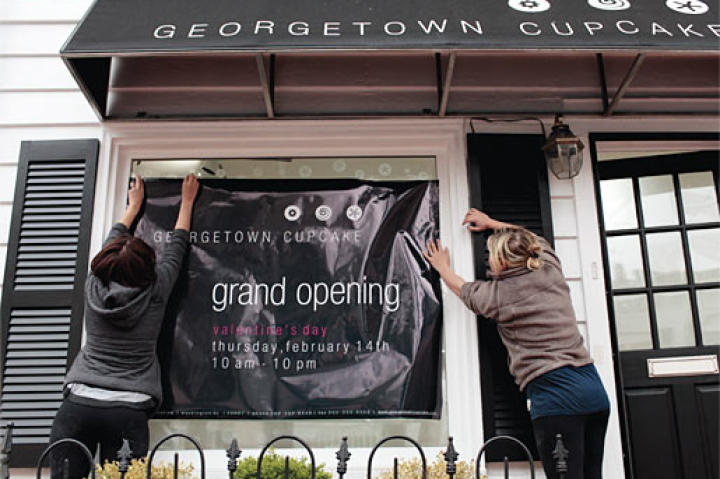 Katherine and Sophie hang a banner just before their grand opening on Feb. 14, 2008.