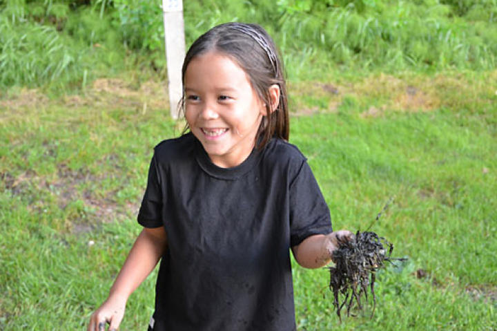 Leah, mid- mud fight, having the time of her life getting her tiny hands messy.