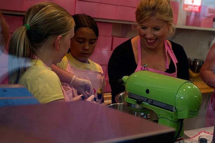 Sophie of DC Cupcakes shows Cara & a friend how to ice a cake- the DC Cupcakes way!
