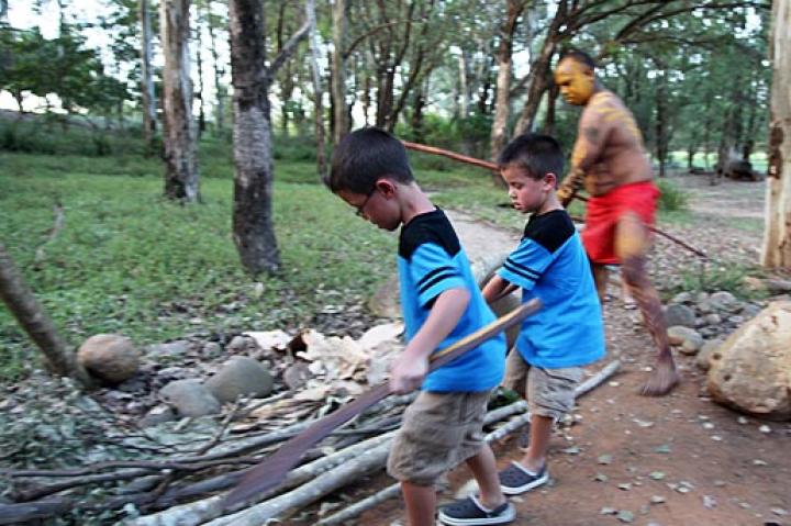Aaden and Collin help gather wood at Aboriginal Village.