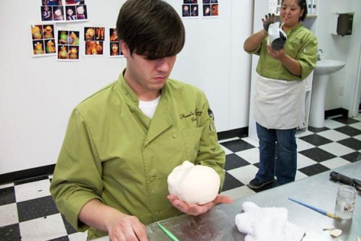 Cake decorator Sonny Robinson works on the head of what will become a cake recreation of one of Terry Fator's ventriloquist dummies.