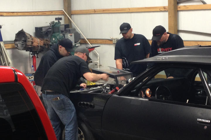 Tyler Priddy (a.k.a Flip), Justin Shearer (a.k.a. Big Chief), Shawn Ellington (a.k.a. Murder Nova) and Danny Parker work on a car together.