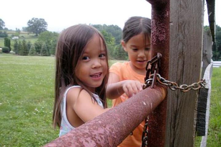 Alexis and Hannah help and lock the gate by the chicken coop.
