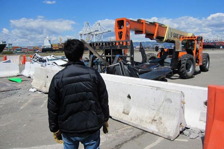 As Grant Imahara looks on, Tory Belleci uses a crane to hoist one of the "Surf and Turf" test cars. Did