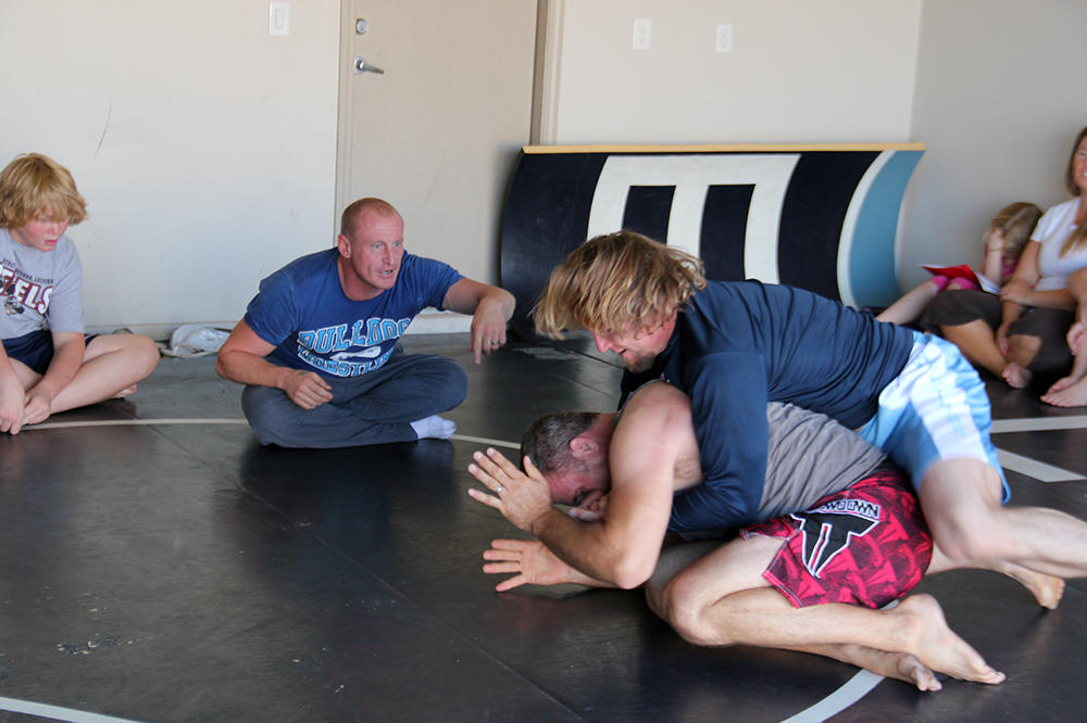 Kody and his friend Brett wrestle while their trainer Sean cheers them on.