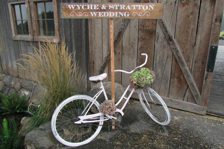A sign and vintage bike greet the wedding guests.