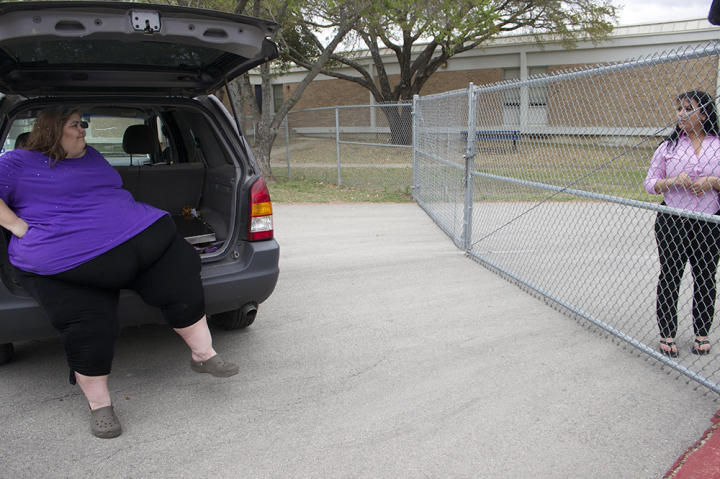 At Hannah's favorite playground, Zsalynn waits in the car while her daughter plays with a friend and another mother watches them.