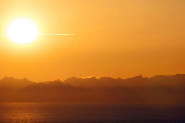 A warm evening sun shines across the bay, as daylight nears its end.