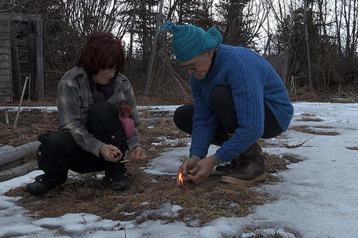Bonnie and Atz Sr. by a small fire.