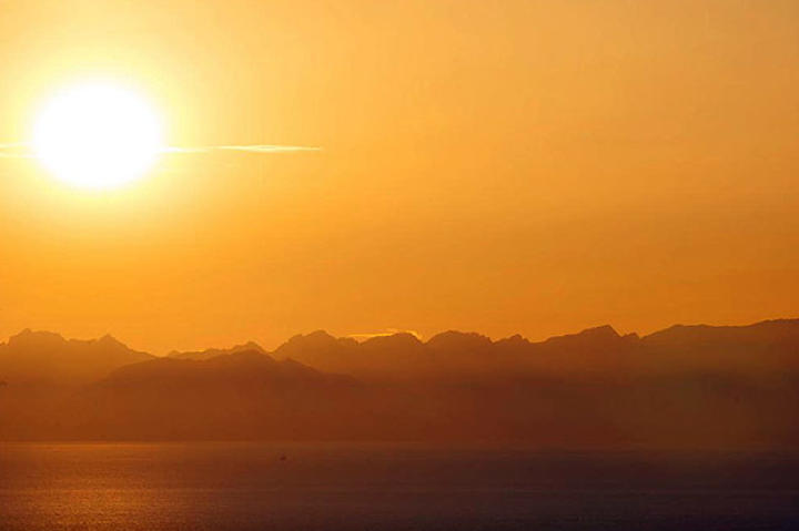 A warm evening sun shines across the bay, as daylight nears its end.