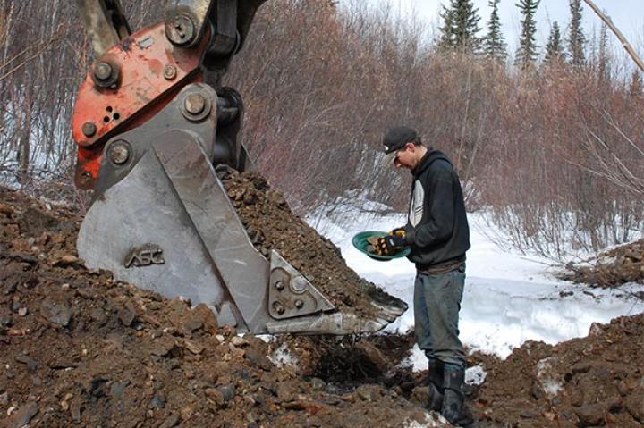 Parker examines a pan of what could be pay dirt.