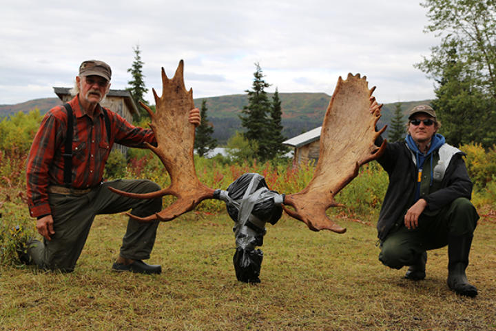 Atz Kilcher and Atz Lee Kilcher kneel aside the moose rack, which they got from their recent moose hunt near Caribou Lake.