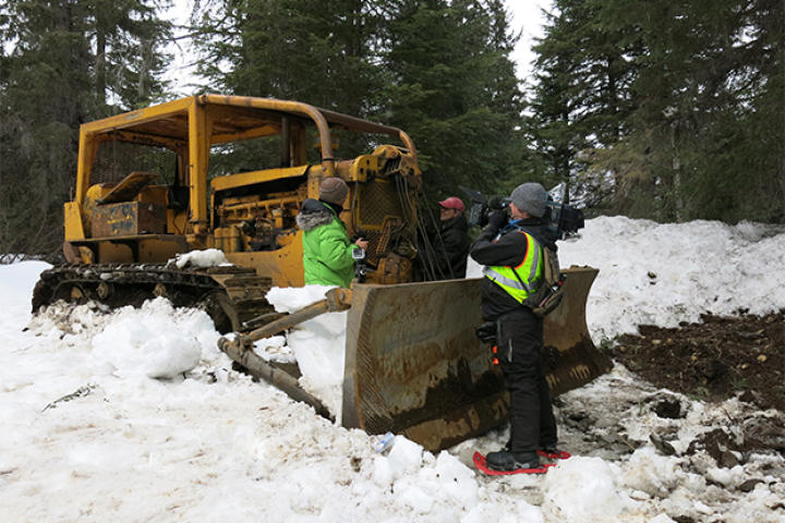 Dustin filming by an excavator.