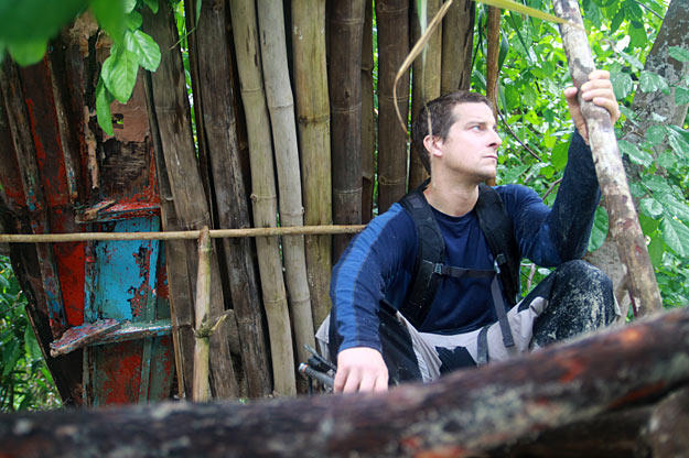 On an island in the Malay Archipelago Bear Grylls sits by his shelter, which he built from bamboo and bits of a broken-up boat. Not only does it protect him from the elements, but its roof is also capable of collecting rain water for drinking.